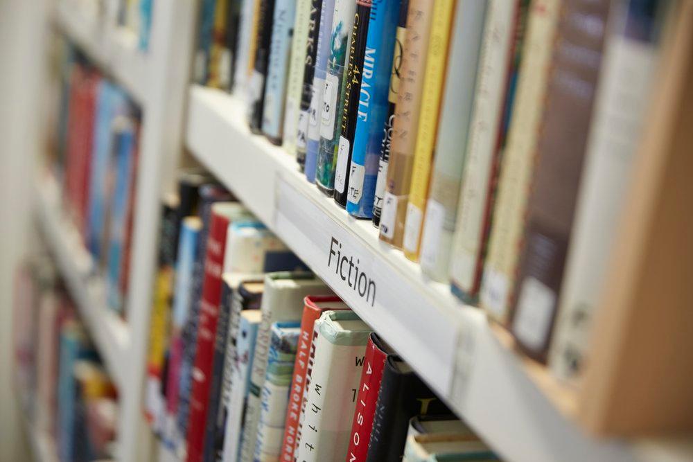 A close-up photo of a bookshelf labeled Fiction.