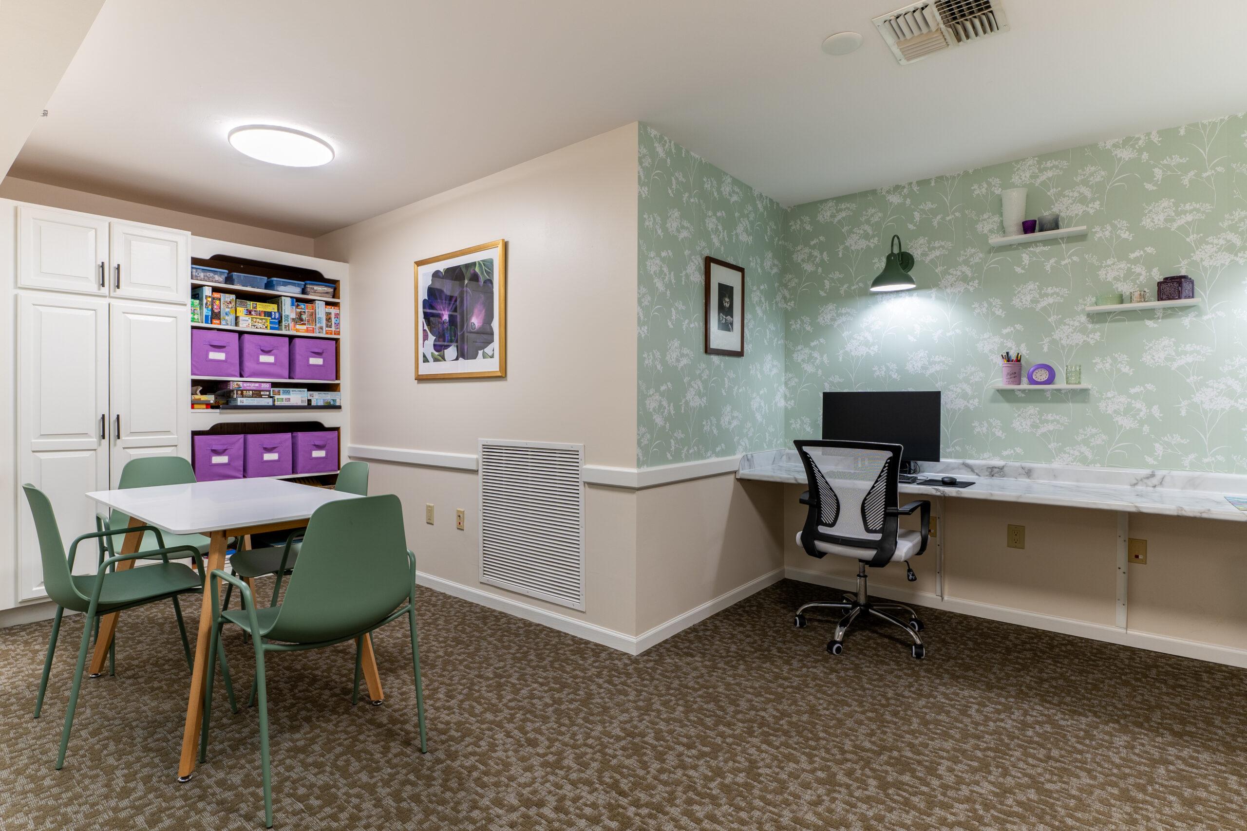 A colorful office space with teal wallpaper and purple accents.