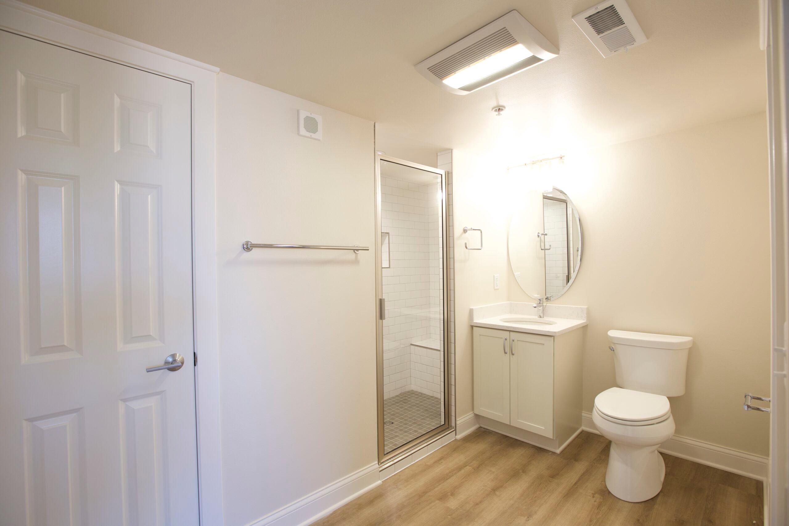 Image of a bathroom with a standing shower that has a bench.